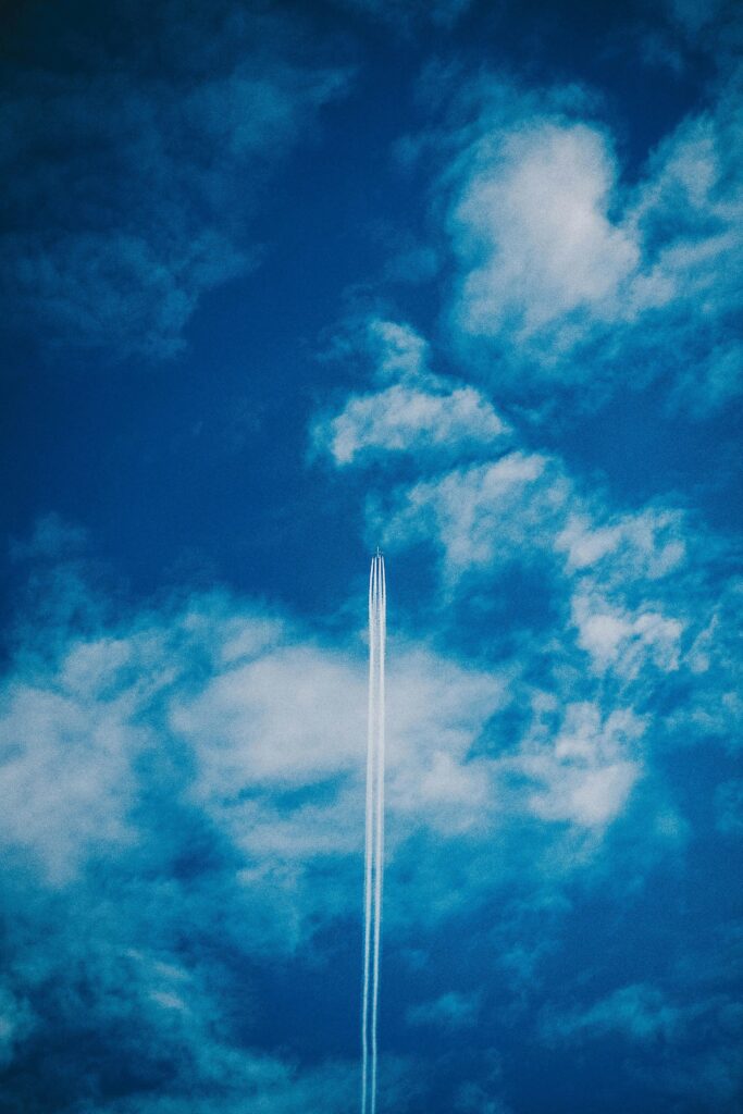 An airplane leaves a contrail across a bright blue sky filled with light clouds, Digital marketing