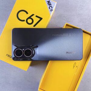 Modern smartphone placed on vibrant yellow packaging, showcasing design and branding.